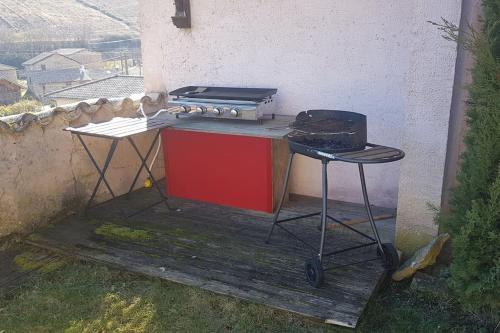 - une cuisinière et un grill sur une terrasse en bois dans l'établissement Charmante maison au calme pour 6 personnes, à Quincié-en-Beaujolais
