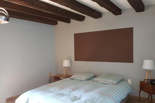 1 dormitorio con 1 cama y una pantalla grande en la pared en Charmante maison au calme pour 6 personnes, en Quincié-en-Beaujolais
