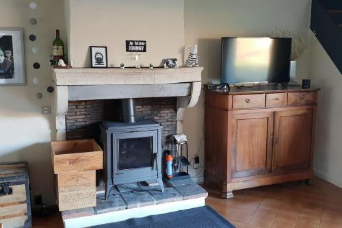 a living room with a fireplace and a television at Charmante maison au calme pour 6 personnes in Quincié-en-Beaujolais