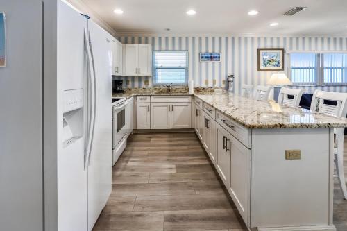 a kitchen with white appliances and a large island at Sunset Villas 3 in Clearwater Beach