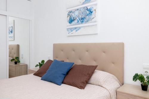 Un dormitorio con una cama con una almohada azul. en Apollo del Mar, en Torrevieja