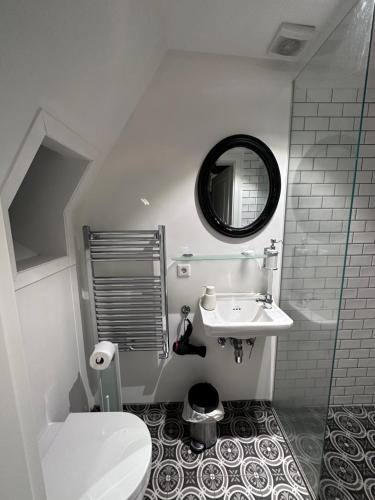 een badkamer met een wastafel, een toilet en een spiegel bij Heart House Guesthouse in Reykjavík