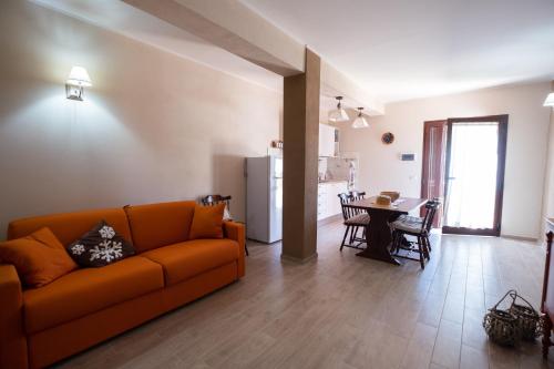 sala de estar con sofá naranja y mesa en Agriturismo I Grappoli, en Alberese