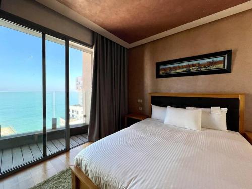 a bedroom with a large bed and a large window at The Panorama of Marina - AppartAli in Casablanca
