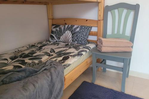 a bed and a chair in a room at Entre mar y PortAventura in Salou