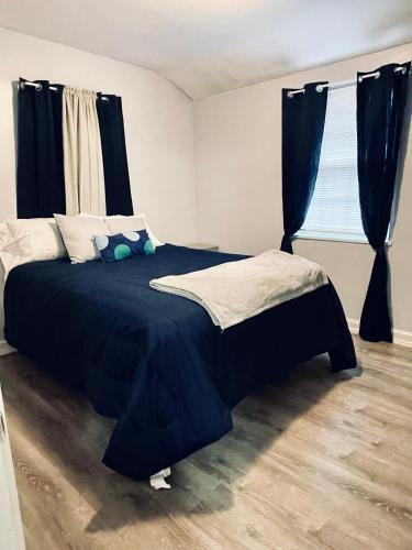 a bedroom with a bed with blue sheets and a window at Renovated guest house in Hyattsville