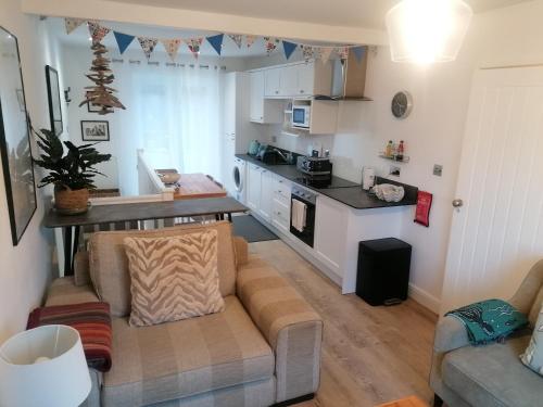 a living room with a couch and a kitchen at Starboard Side Brixham - Ideal seaside getaway with parking in Brixham