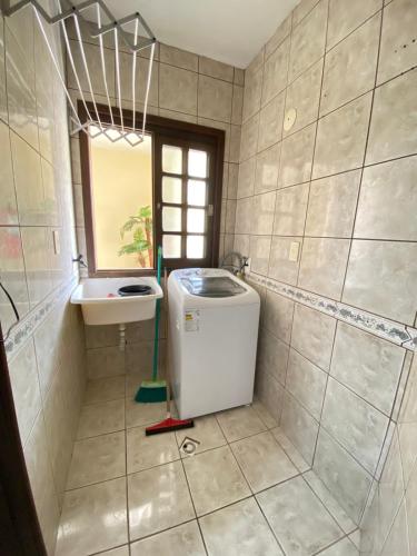 a bathroom with a sink and a washing machine at Residencial Marítimos in Torres