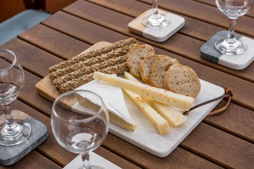 a plate of cheese and bread on a table with wine glasses at Sant'Agata in Lixouri