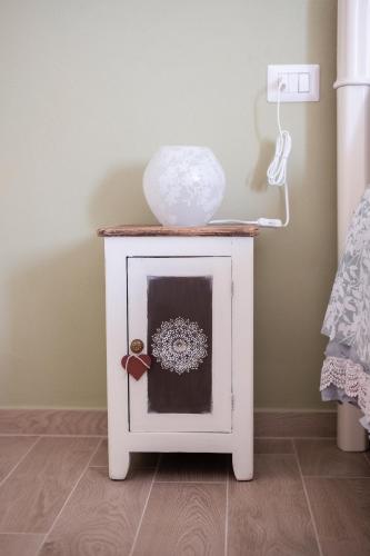 a white table with a vase on top of it at Agriturismo I Grappoli in Alberese