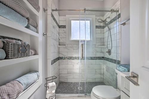 a white bathroom with a shower with a toilet at Cozy Beach Bungalow Near Galveston Seawall and Pier in Galveston