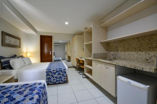 um quarto de hotel com uma cama e uma cozinha em Littoral Express em João Pessoa