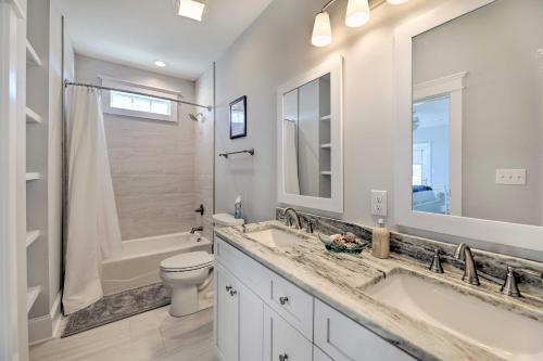 a white bathroom with two sinks and a toilet at Gorgeous Emerald Isle Getaway Walk to Beach! in Emerald Isle