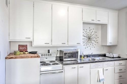 a white kitchen with white cabinets and a stove top oven at Convenient Lead Vacation Rental! in Lead