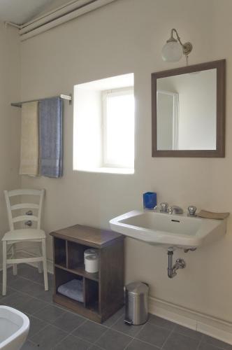 a bathroom with a sink and a toilet and a mirror at B&B Corte delle Muse in San Felice del Benaco