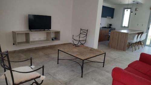een woonkamer met een rode bank en een tv bij Duplex en barrio privado in Mendoza