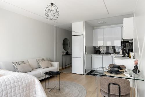a white living room with a white couch and a kitchen at Bianca in Turku