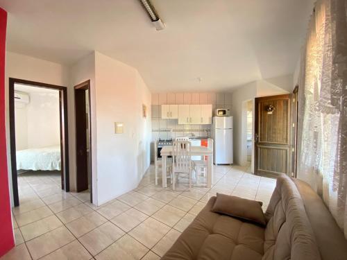 un soggiorno con divano e cucina di Residencial Marítimos a Torres