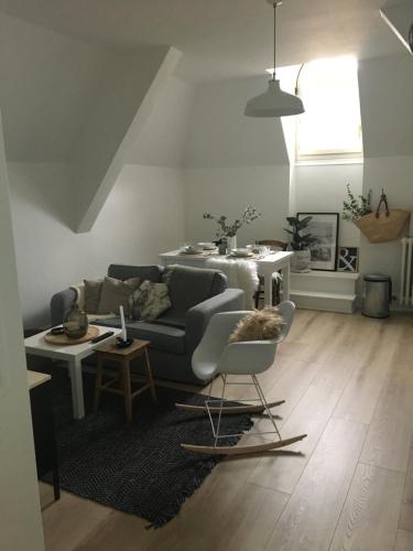 uma sala de estar com um sofá e uma mesa em les chambres de pauline appartements em Albertville