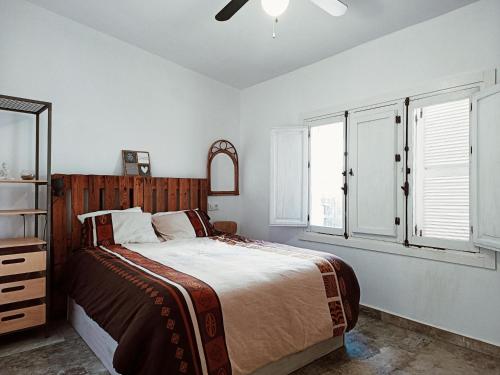 a bedroom with a bed and a dresser and windows at Chalet en San José, Cabo de Gata-Níjar. in San José