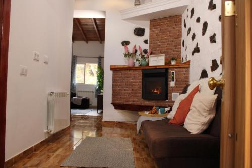 sala de estar con sofá y chimenea en Finca El cole, en Las Palmas de Gran Canaria