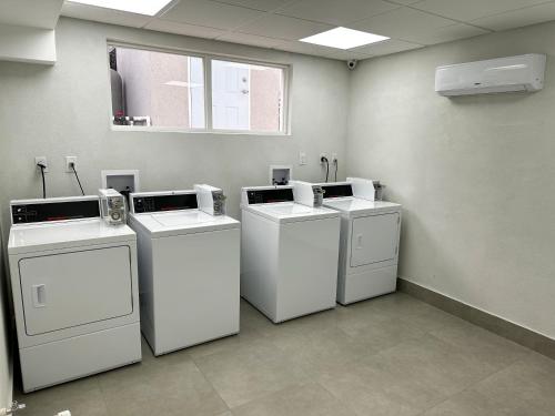 a room with four washing machines and a window at Blue Haven Holiday Apartments in Christ Church
