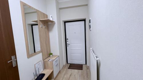 キシナウにあるCozy apartment in Chisinauの白い扉と鏡のある廊下
