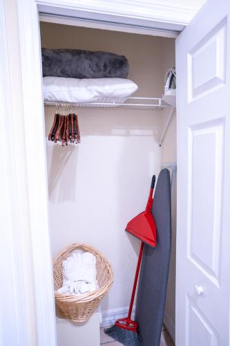 a closet with a red mop and a basket at The Capri at Siesta in Siesta Key