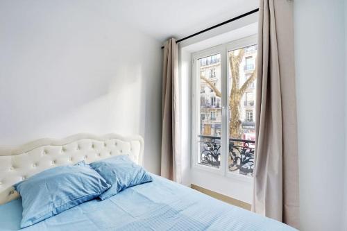 une chambre avec un lit et une fenêtre dans l'établissement Magnifique 3 pièces Paris 18ème, à Paris