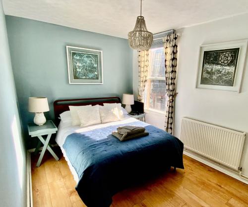 a bedroom with a bed and a blue wall at Viewing Room, seaview 30 seconds from beach in Broadstairs