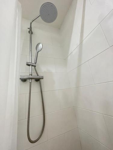 a shower with a shower head in a bathroom at Cosy studio flat for students or workers. in Bedford
