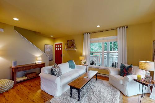una sala de estar con 2 sofás blancos y una mesa. en Bay View Retreat, en Eastsound