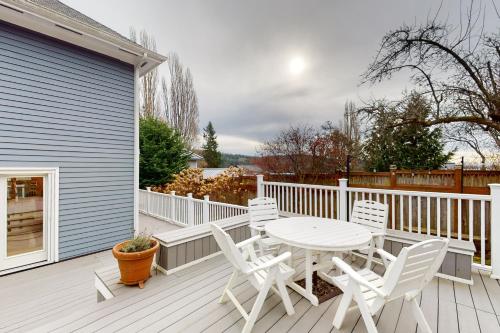 a white deck with a table and chairs on it at Bay View Retreat in Eastsound