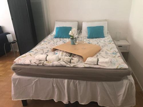 Una cama con almohadas azules y una mesa encima. en Stylish spacious studio near centre by the sea, en Helsinki