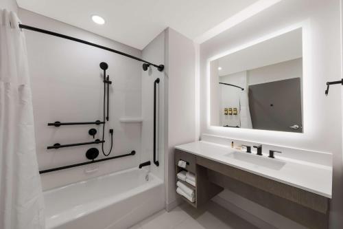 een badkamer met een bad, een wastafel en een spiegel bij Best Western Plus Parry Sound in Parry Sound