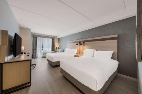 een hotelkamer met 2 bedden en een flatscreen-tv bij Best Western Plus Parry Sound in Parry Sound