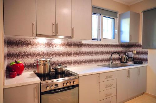a kitchen with white cabinets and a stove top oven at Phivos Home & Garden in Messini