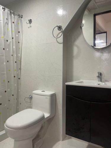 a bathroom with a toilet and a sink and a mirror at 14 Departamento acogedor y nuevo en Miraflores in Lima