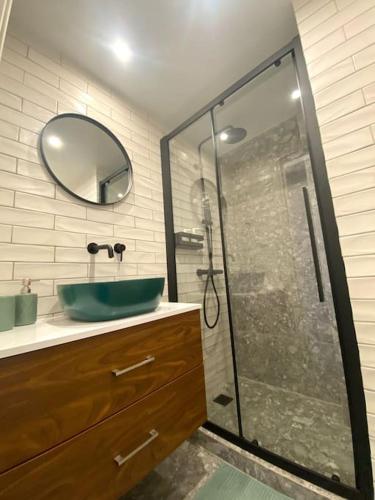 a bathroom with a sink and a shower with a mirror at Piraeus Apartment for rent in Piraeus