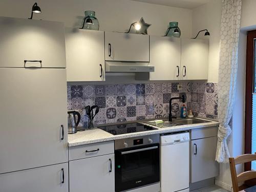 a kitchen with white cabinets and a sink at B&B Worpsweder Blick in Osterholz-Scharmbeck