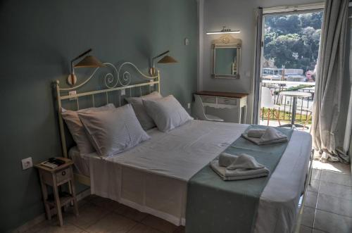 a bedroom with a large bed with a large window at Astacos Studios in Paleokastritsa