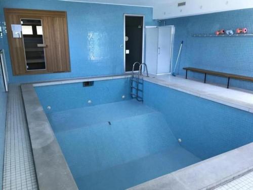 a blue kitchen with a large swimming pool at Schönes, exklusives Apartment, direkt am Luganersee, modernes Interieur, Außenpool in Maroggia