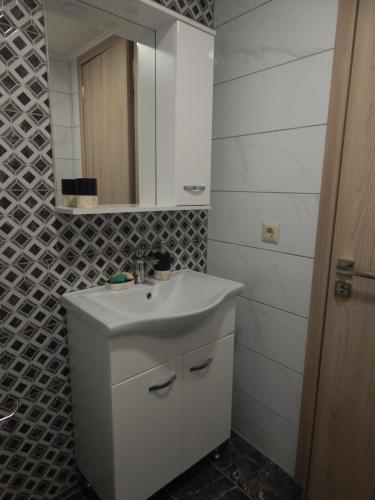 a bathroom with a white sink and a mirror at Vera City Apartment in Zakynthos