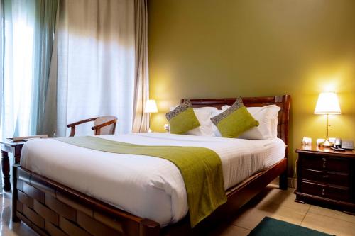 a bedroom with a large bed and a window at Legend Boutique Hotel in Kigali