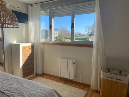 1 dormitorio con cama y ventana grande en Ático nuevo en Arteixo con plaza de garaje, en Arteixo