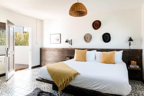 a bedroom with a large bed with white sheets and orange pillows at Cuyama Buckhorn in New Cuyama