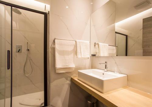 a white bathroom with a sink and a shower at Corso Vittorio B&B in Pescara