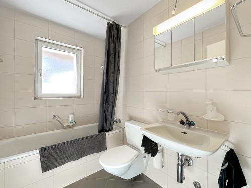 a white bathroom with a toilet and a sink at Eagle apartment with splendid and direct view of the Matterhorn in Zermatt
