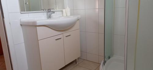 un bagno bianco con lavandino e doccia di Apartmani Barišić a Trogir