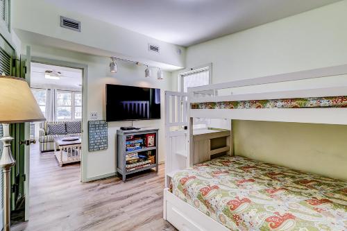 a bedroom with a bunk bed and a television at Moonshell 3 in Hilton Head Island